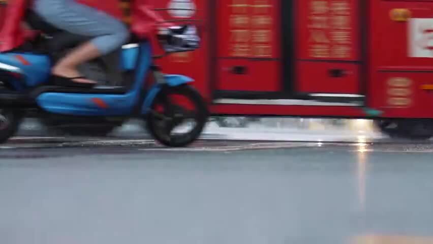 下雨天撑伞过马路的行人脚步特写