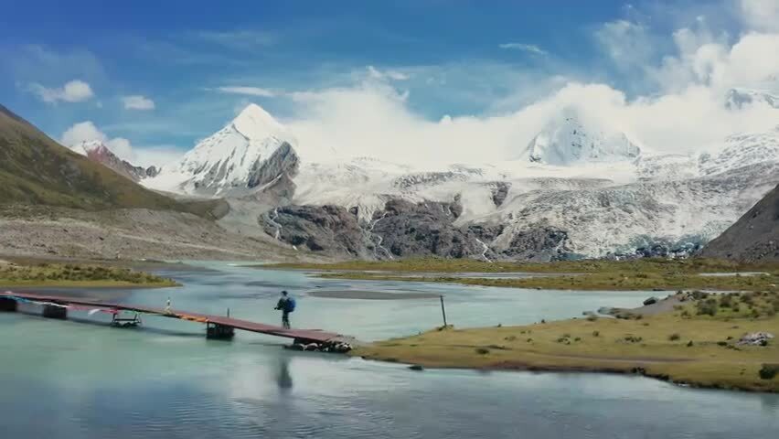 背包客走在萨普神山下的木桥上