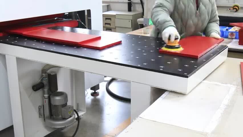 工人用机器打磨红色板材的工作场景