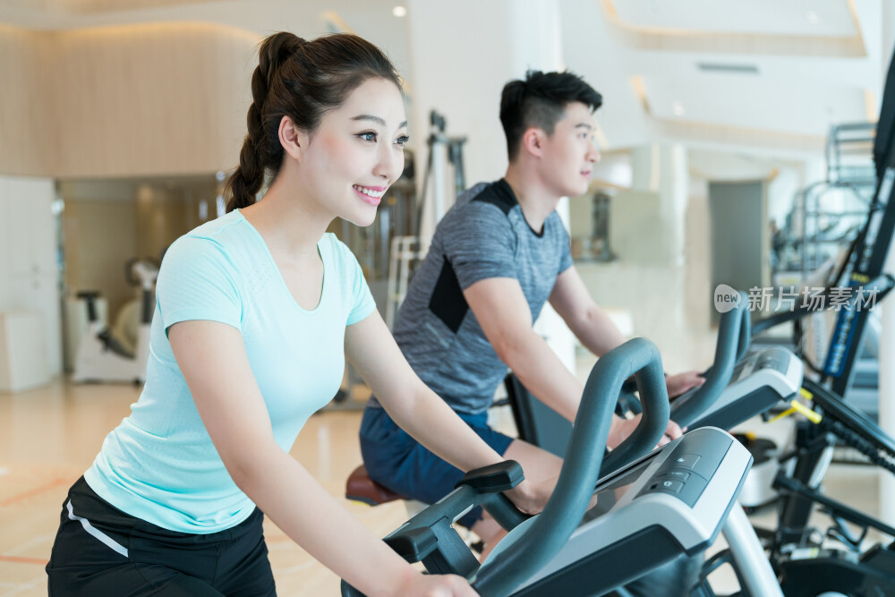 年轻男子和女子在健身房健身