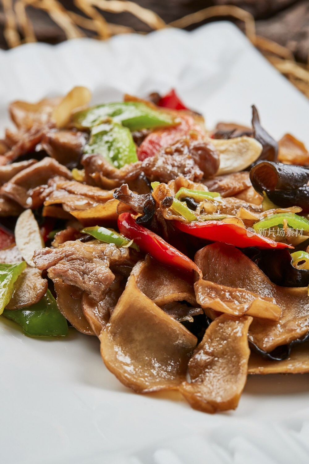 白色瓷盘装的肉炒山珍杂菌