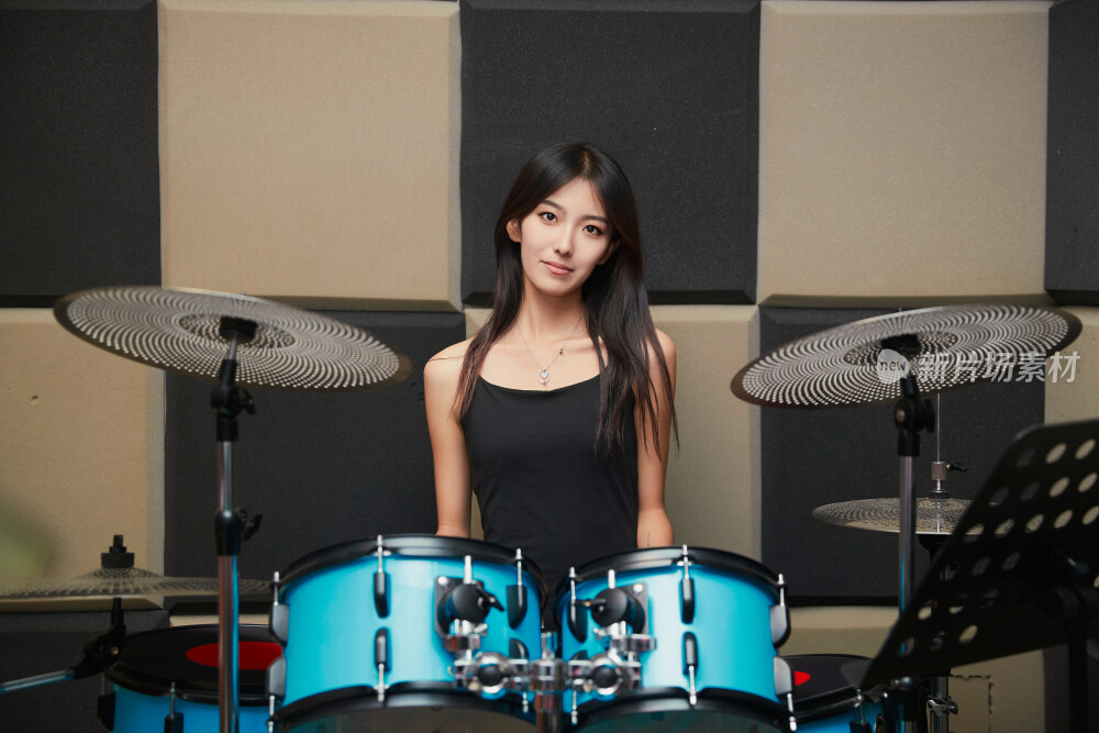 在排练室打爵士鼓的亚洲少女