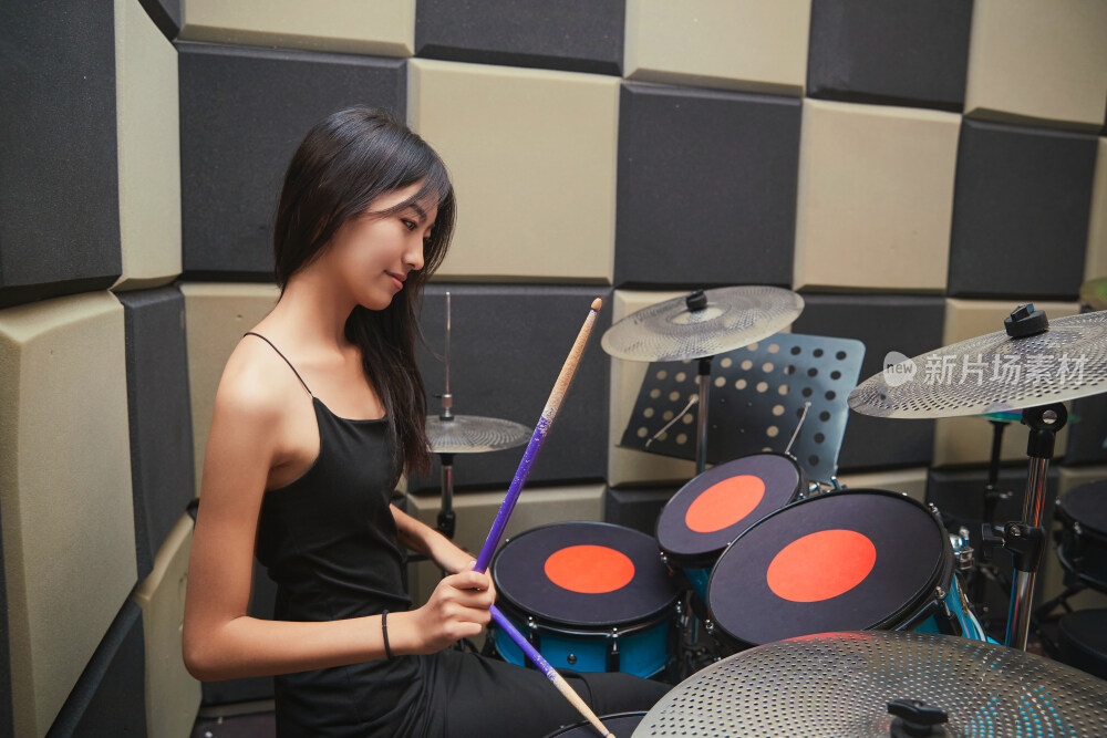 在排练室打爵士鼓的亚洲少女