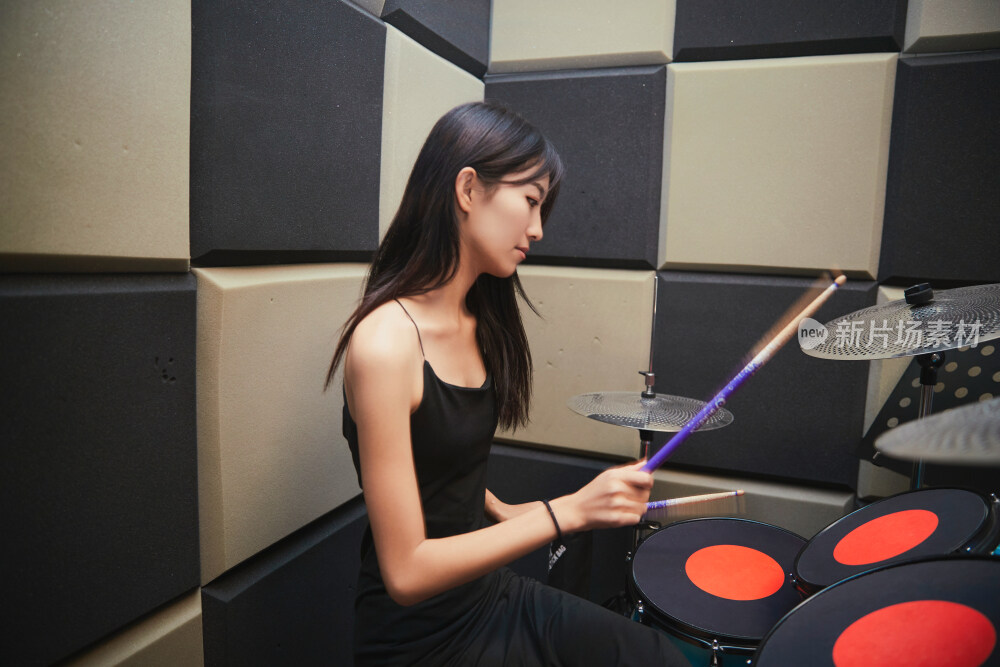 在排练室打爵士鼓的亚洲少女