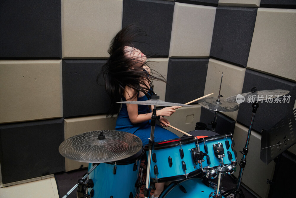 在排练室打爵士鼓的亚洲少女