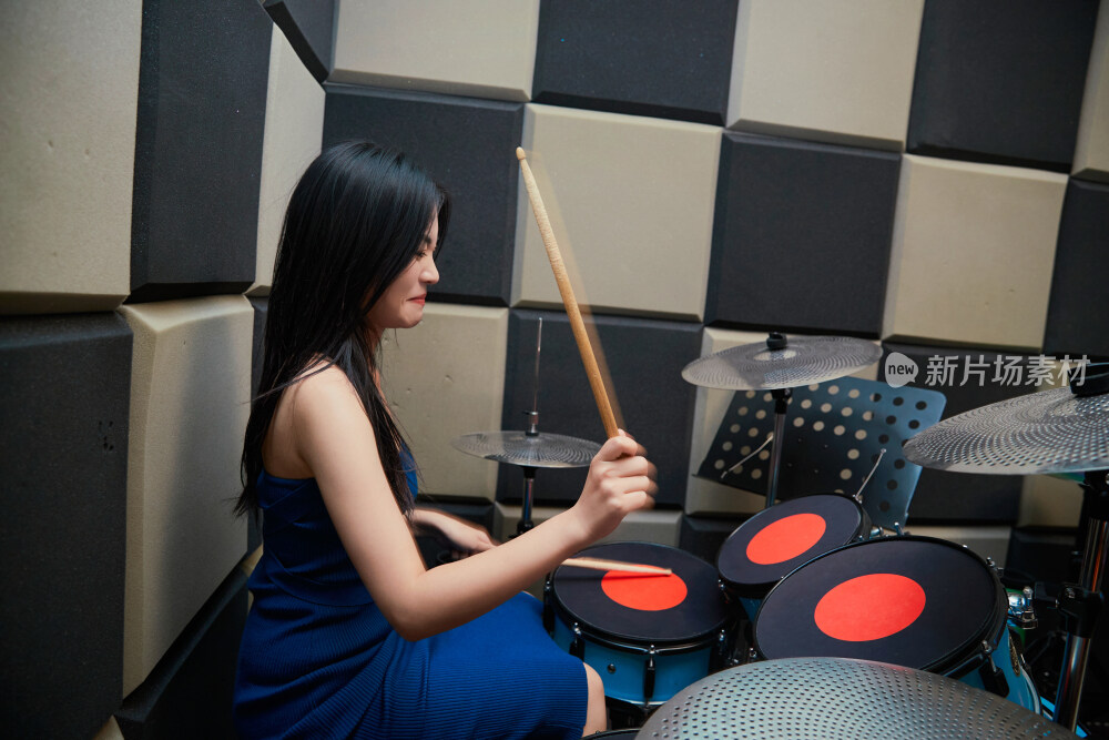 在排练室打爵士鼓的亚洲少女