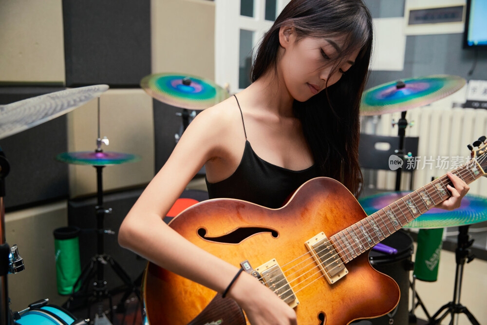 在录音室排练演奏的亚洲少女