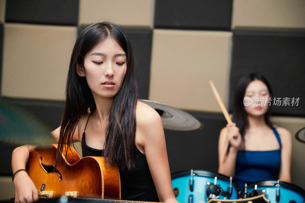 在录音室排练演奏的亚洲少女