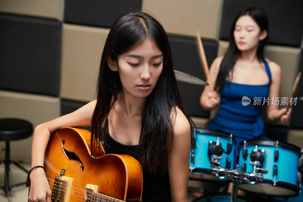 在录音室排练演奏的亚洲少女