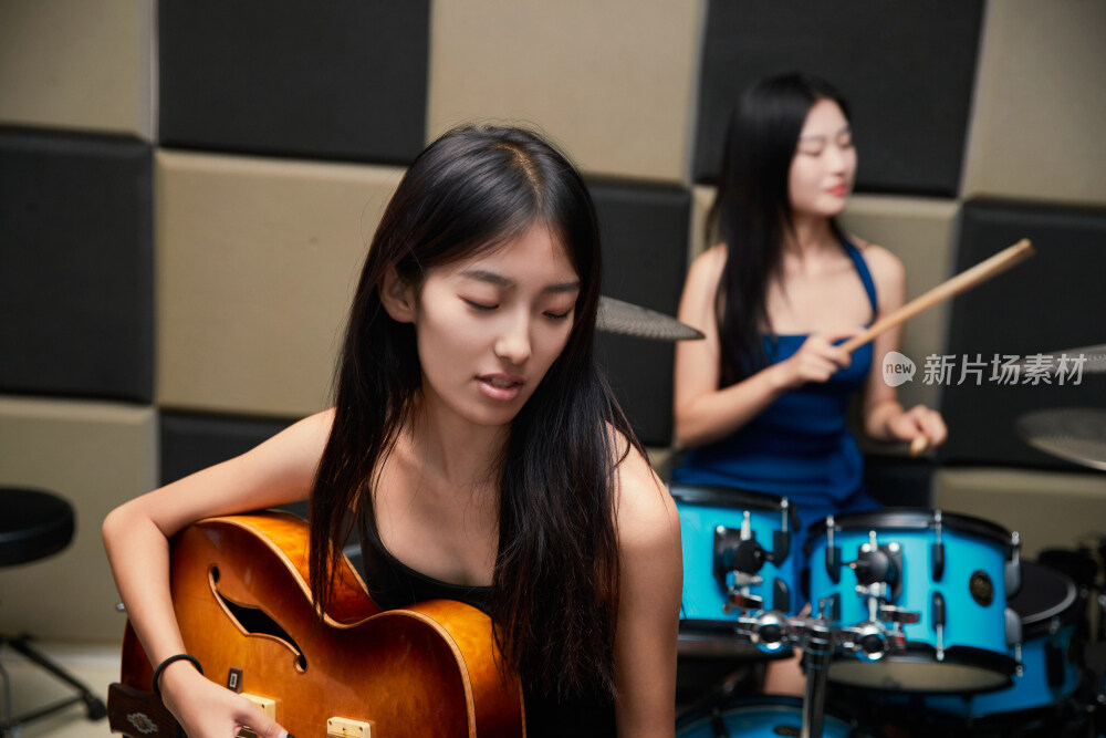 在录音室排练演奏的亚洲少女