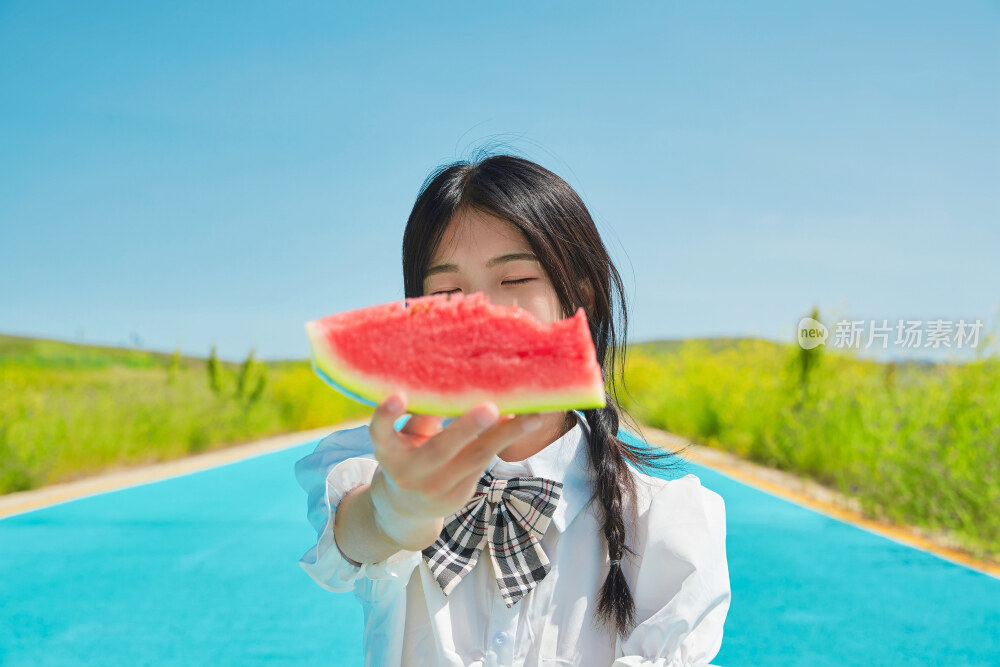 夏日户外湖边彩色公路上玩耍吃西瓜的少女