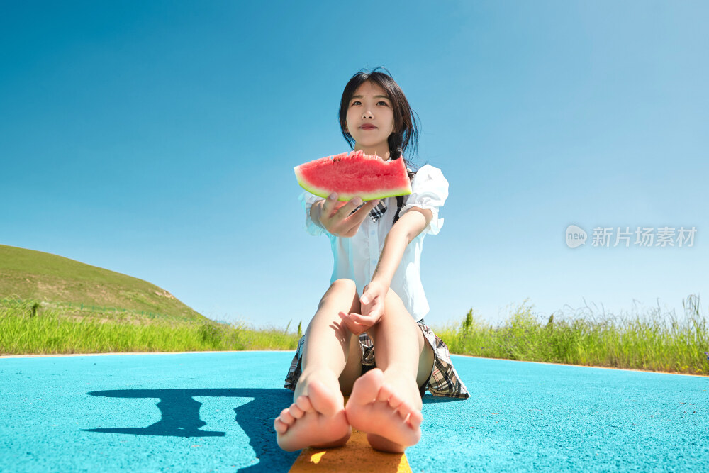 夏日户外湖边彩色公路上玩耍吃西瓜的少女