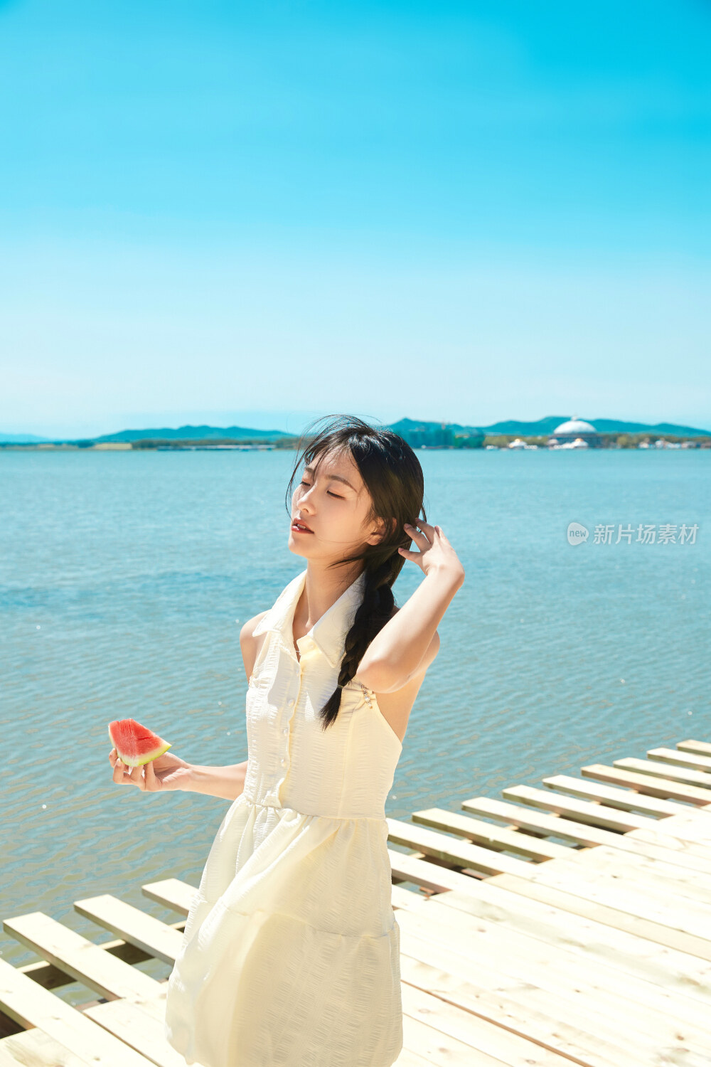 夏日户外湖边彩色公路上玩耍吃西瓜的少女