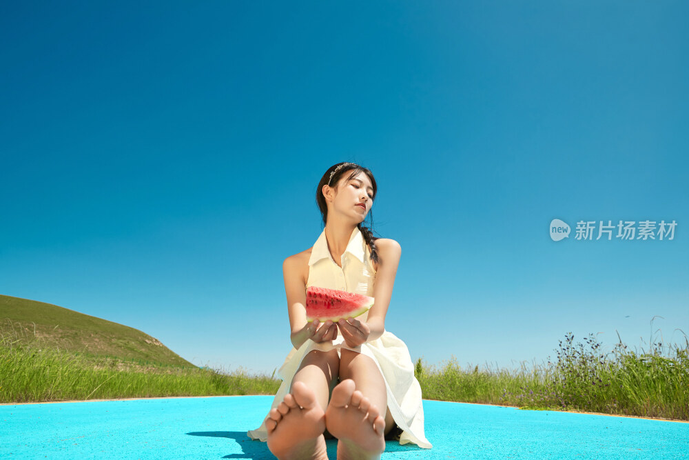 夏日户外湖边彩色公路上玩耍吃西瓜的少女