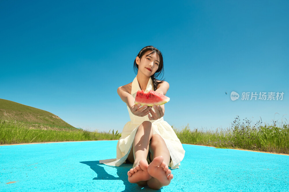 夏日户外湖边彩色公路上玩耍吃西瓜的少女