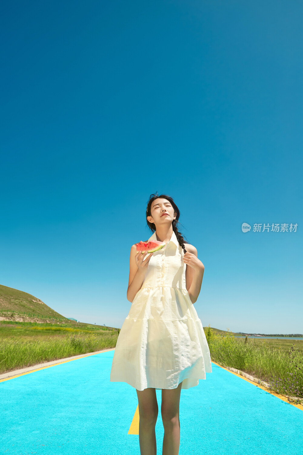 夏日户外湖边彩色公路上玩耍吃西瓜的少女