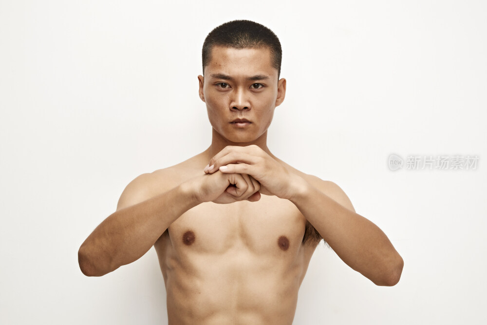 白色背景下演示自由搏击动作的亚洲功夫男性