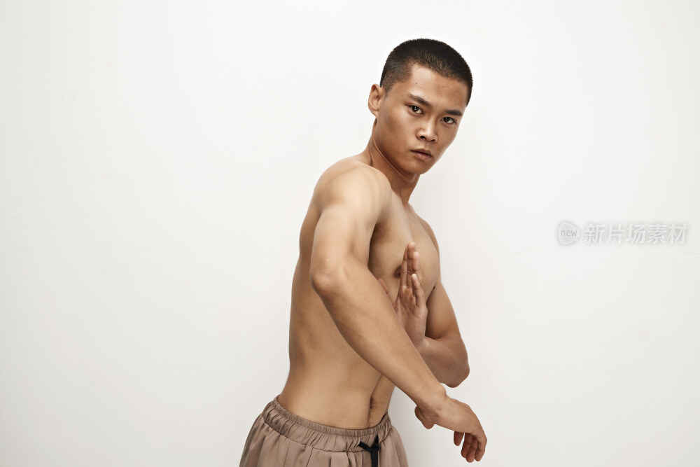 白色背景下演示自由搏击动作的亚洲功夫男性