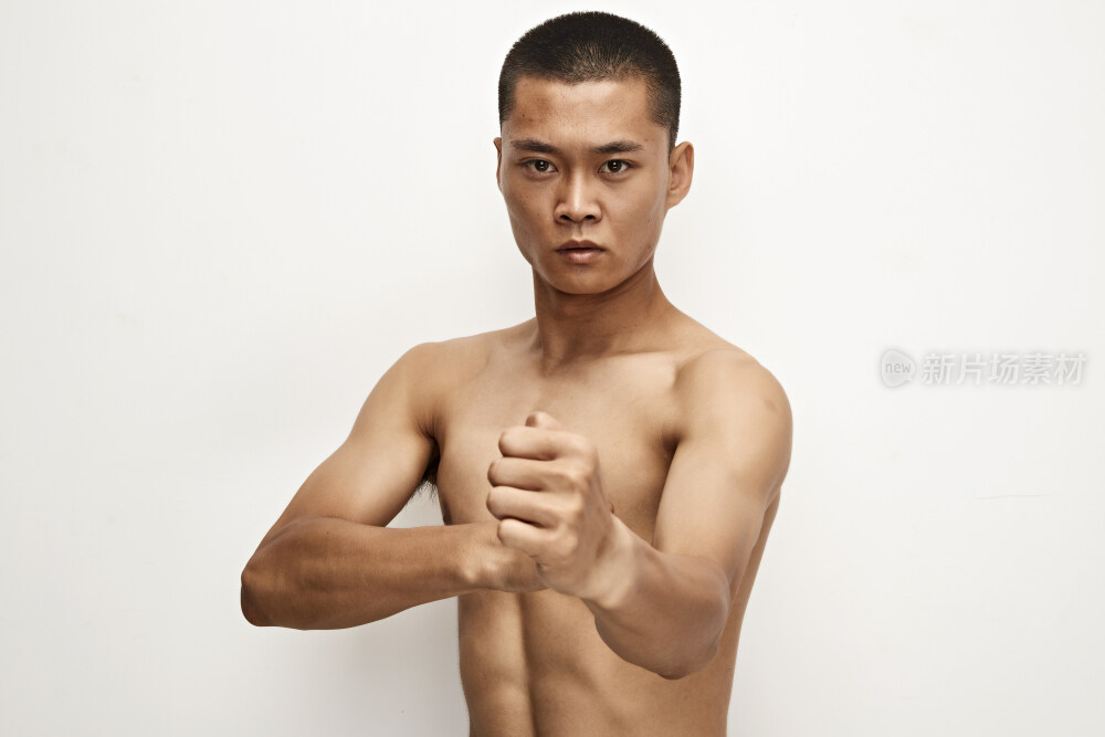 白色背景下演示自由搏击动作的亚洲功夫男性