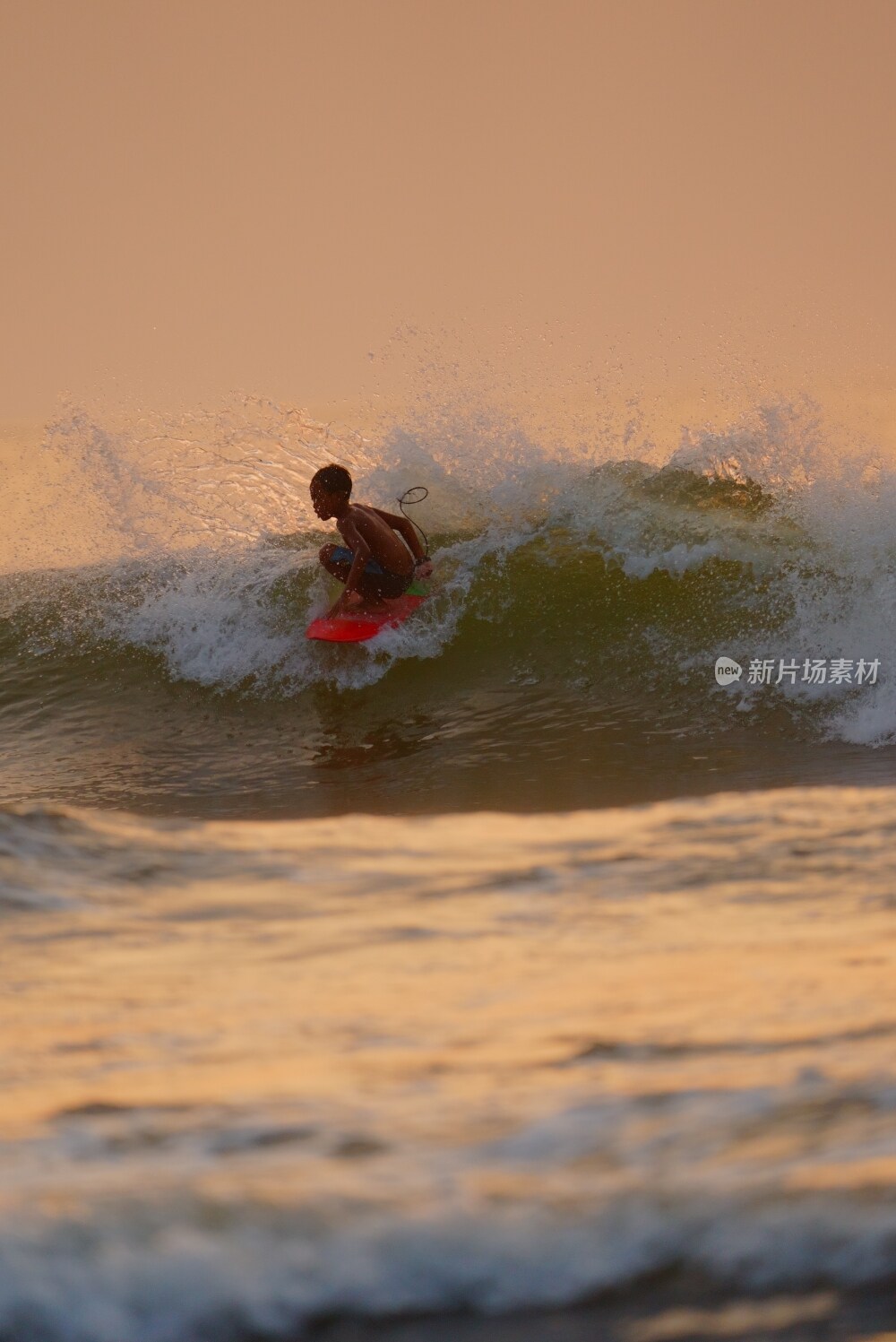 夕阳下的冲浪男孩