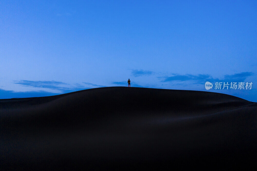 站着沙漠中沙丘上的背影