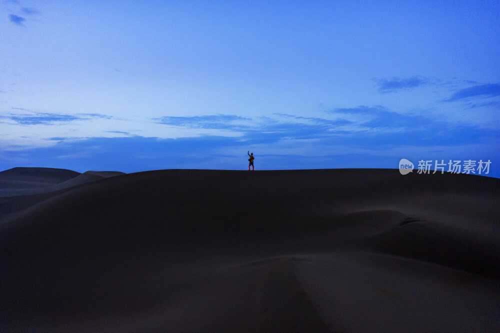 站着沙漠中沙丘上的背影