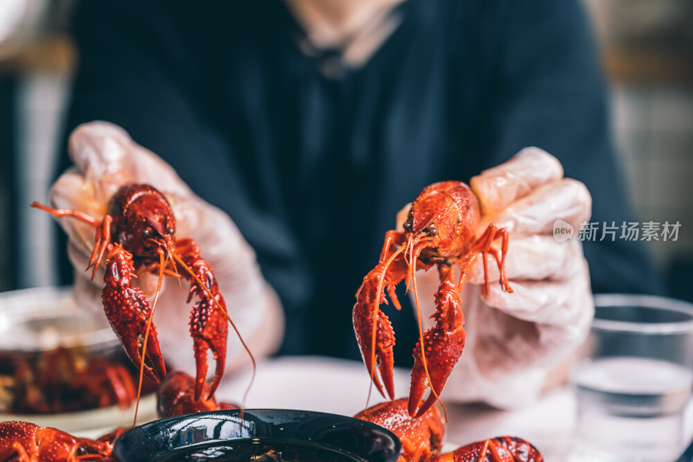 一个人双手拿着中国夏季传统美食清蒸小龙虾