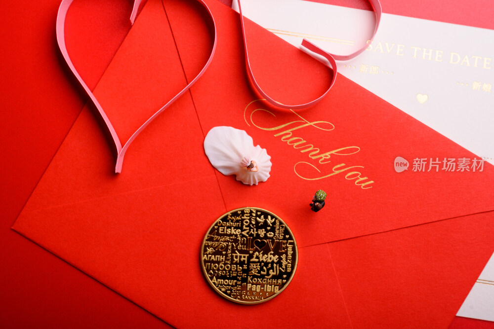 红色背景上放着的婚礼请柬和微缩景观婚礼