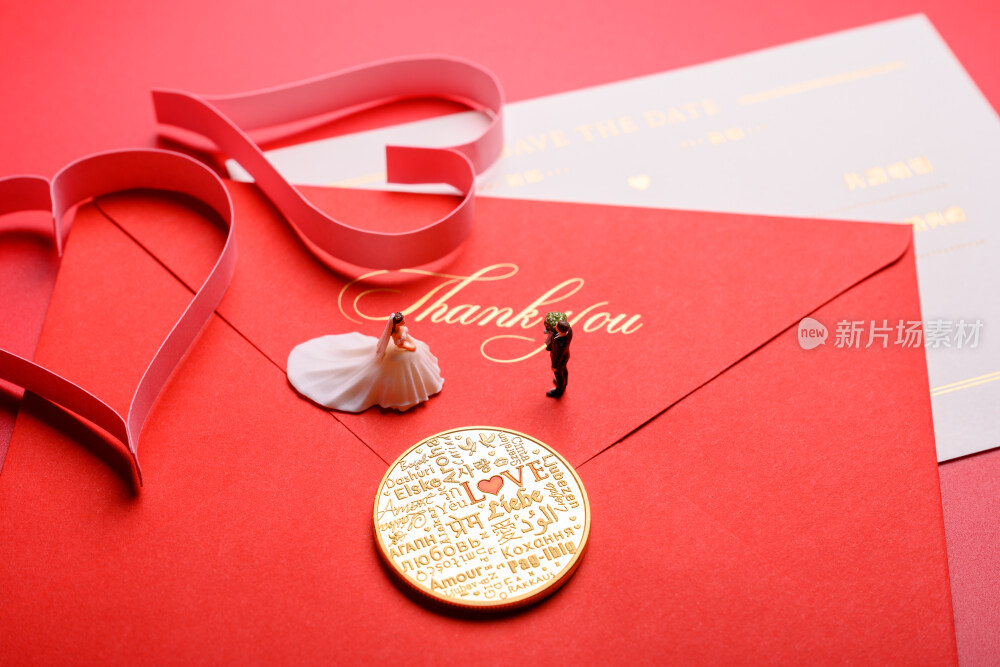 红色背景上放着的婚礼请柬和微缩景观婚礼