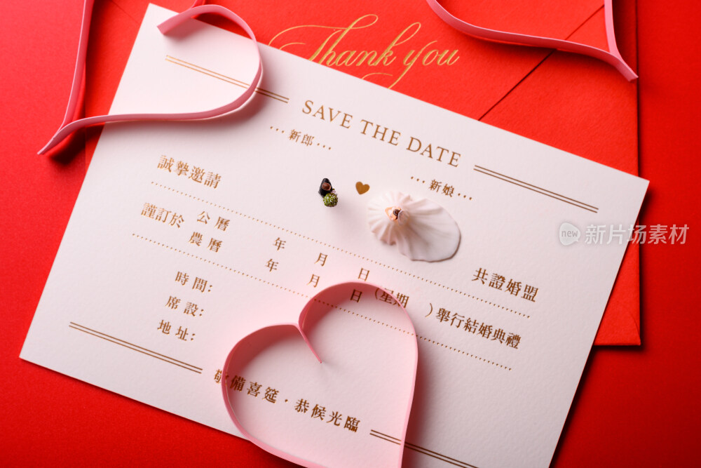 红色背景上放着的婚礼请柬和微缩景观婚礼