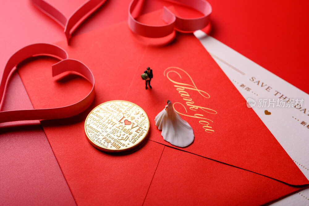 红色背景上放着的婚礼请柬和微缩景观婚礼
