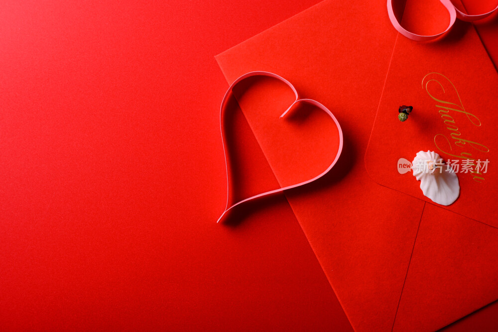 红色背景上放着的婚礼请柬和微缩景观婚礼