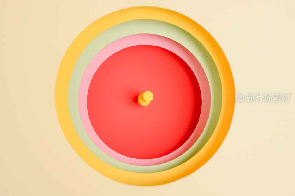 用卡纸叠成的一层一层彩色圆洞中钉着的图钉