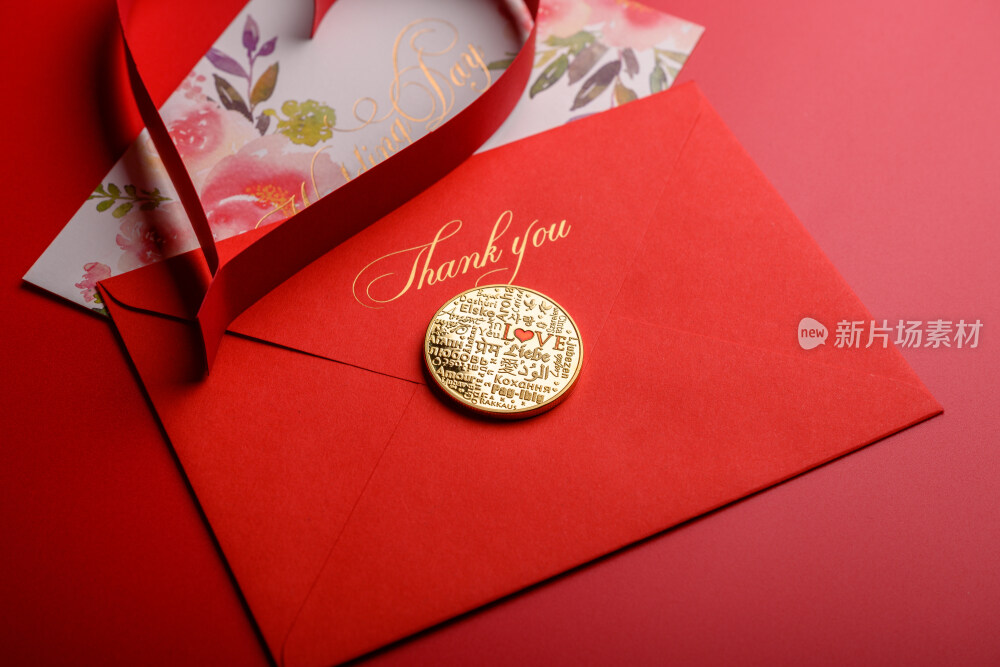 红色背景上放着的婚礼请柬和微缩景观婚礼