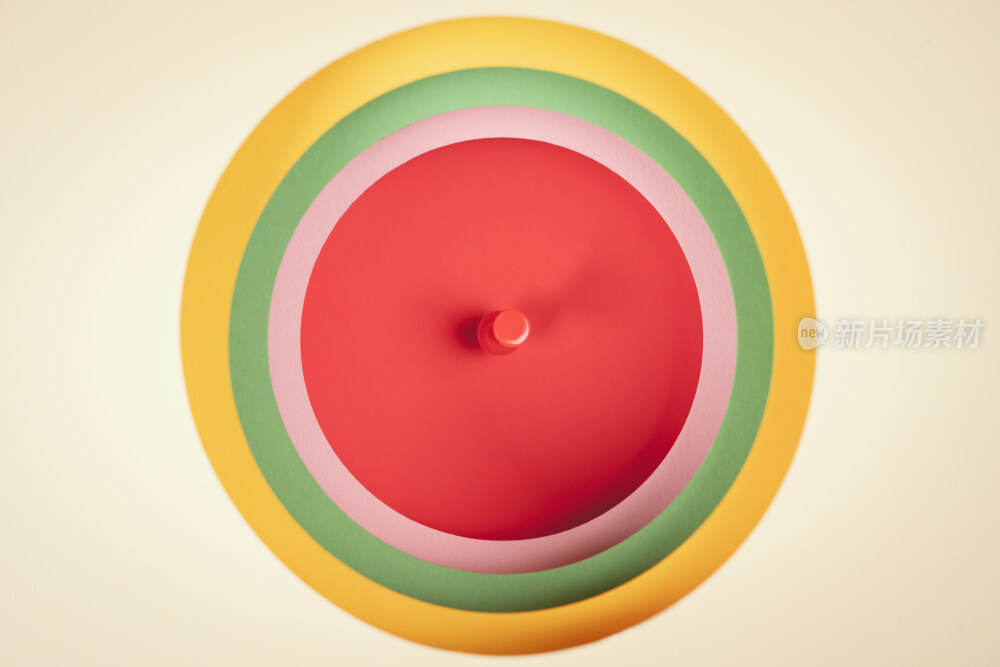 用卡纸迭成的一层一层彩色圆洞中钉着的图钉